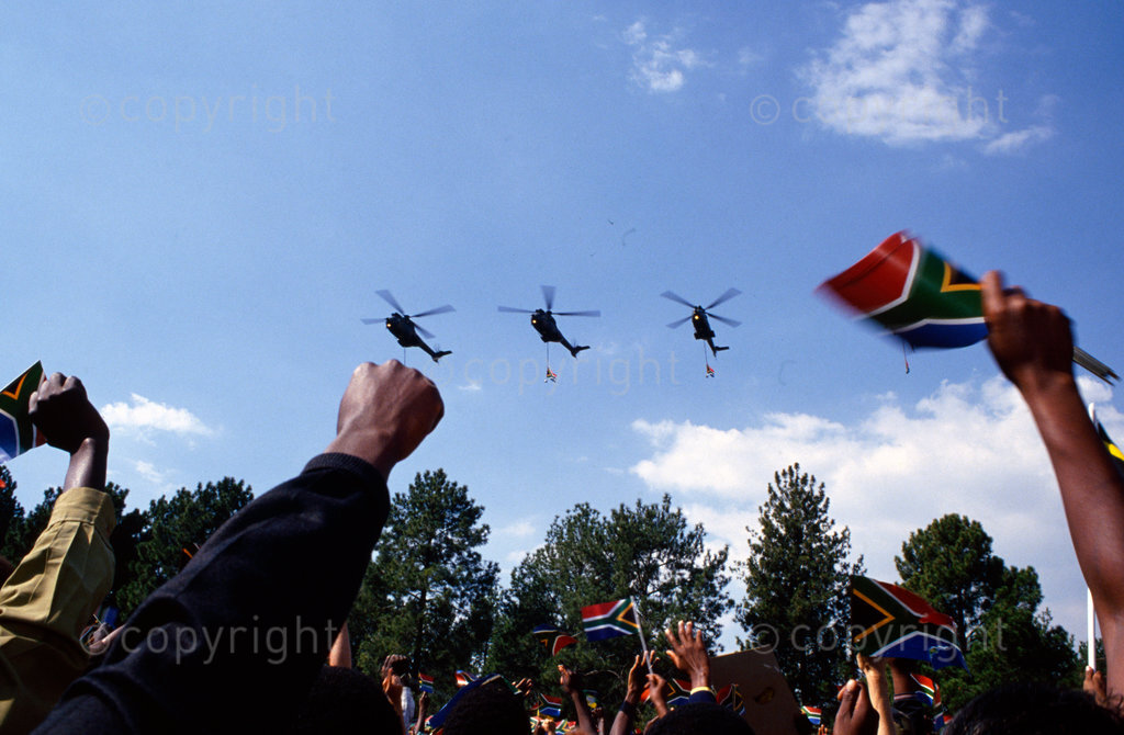 10 May 1994 - Military helicopters bearing the new South African flag, fly over the crowds at the inauguration of Nelson Mandela at the Union Buildings in Pretoria.
Photo by Gidele Wulfsohn / african.pictures