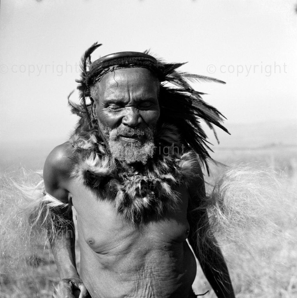 Mapela Zungu aged ninety years at Chief Mgcinizeni Zungus village. He is wearing a Zulu headdress made from Sakabula feathers.