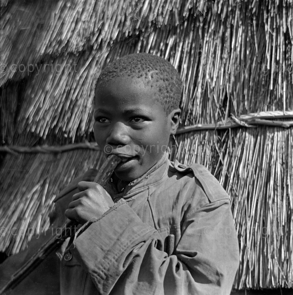 Zulu herd boy playing his Igekle flute at Chief Mhlolutinis village.