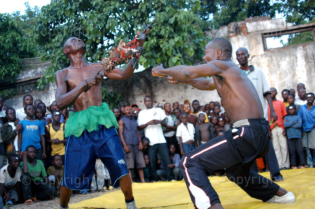 AFRICA, DEMOCRATIC REPUBLIC OF CONGO- Zombi, left, fighting against Etoile using his fetish stick in Mbandaka. The fight is not real but staged and the rivals use fetish statues and sticks to defeat the other. (Photo by: Africa 24 Media / Riccardo Gangale)ALL RIGHTS RESERVED