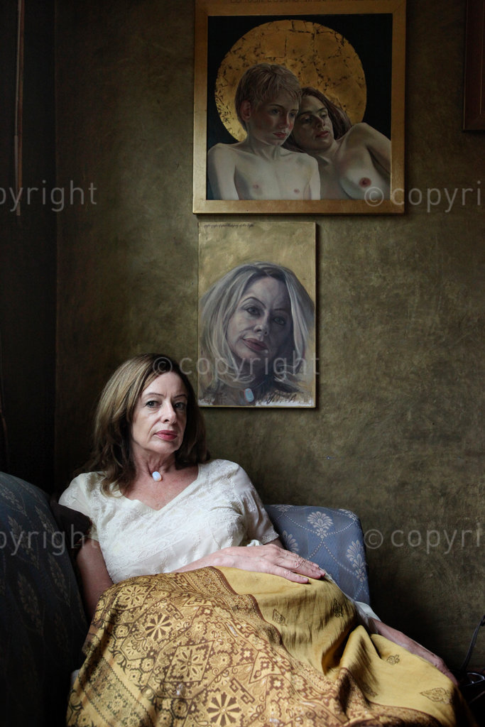 South African artist, Reshada Crouse, sits beneath her portraits of her children hanging in her home in Yeoville, Johannesburg.