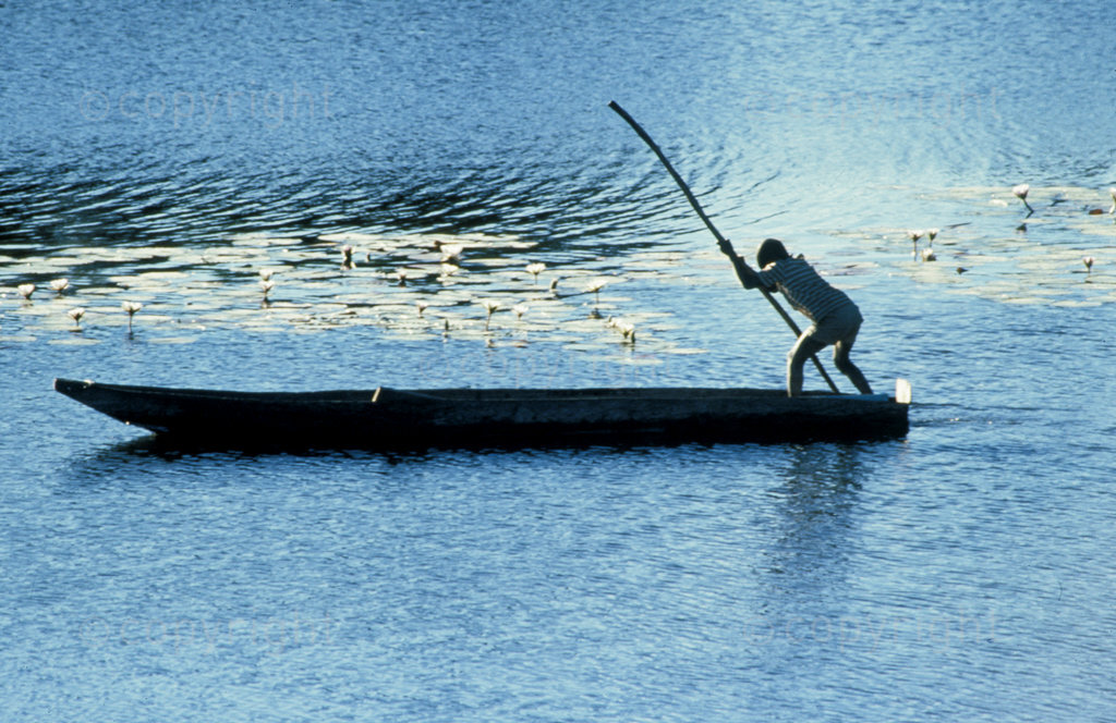 Young boy poles a mukora, Okavango Delta 1991