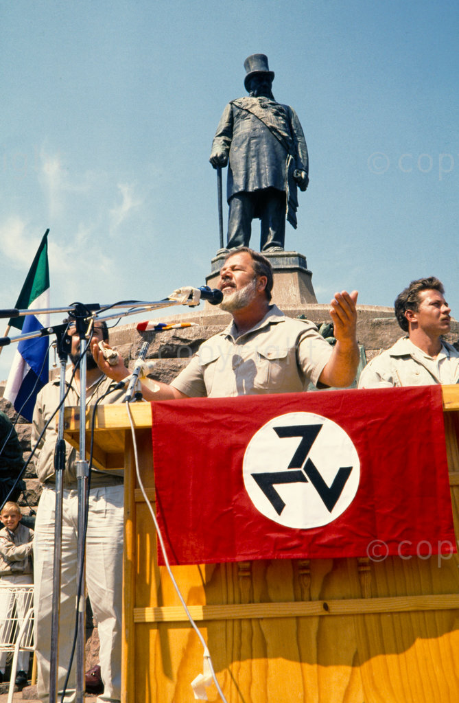 [No data supplied]

South Africa
Gauteng
Pretoria

Organisations
Afrikaner Weerstandsbeweging  (AWB) rallly
(Afrikaner Resistance Movement)

AWB rally in Pretoria
1989/09/23
 Eugène Terre'Blanche (founder and leader of the AWB)
Statue of Paul Kruger

AWB insignia

1989/09/23