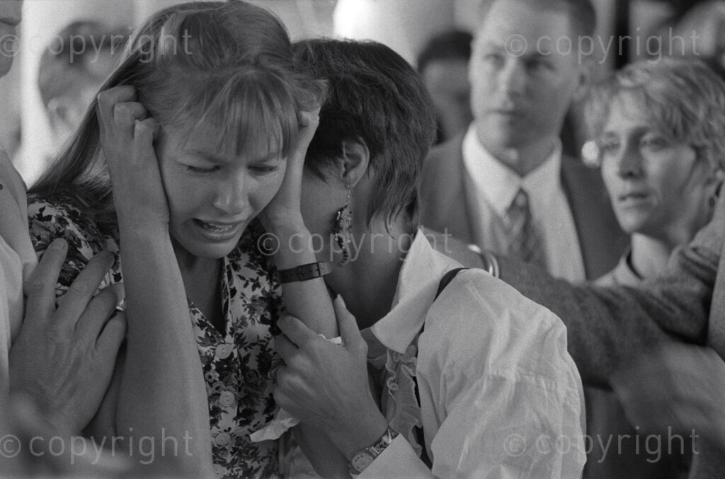 Ken Oosterbroek's funeral. Monica Oosterbroek (hands to head) weeping at the funeral of her husband, Ken Oosterbroek. 
Photo Credit: Ken Oosterbroek / african.pictures