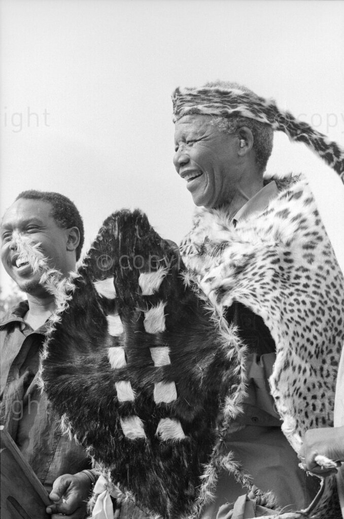 South Africa, 1987-1994. Nelson Mandela in traditional clothing with shield, headdress and leopard-skin cloak.
Photo Credit: Ken Oosterbroek / african.pictures Photo Credit: Ken Oosterbroek / african.pictures