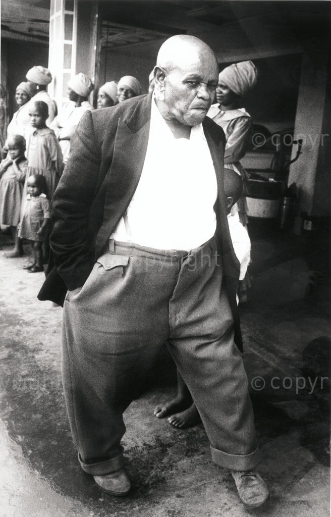 Verwoerd's 'inyanga', Khotso Sethunsa, walks past Kumalo at his compound in Kokstad in the early 1970s