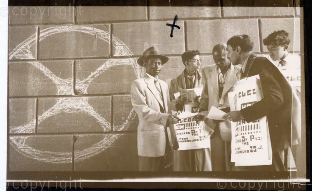 South Africa, 19550101. PHOTO: Eli Weinberg.

Three men canvass members of the public to elect delegates for the Congress of the People to be held on the 25 and 26 June 1955 in Kliptown, Johannesburg. They wear printed posters which read 'ELECT YOUR DELEGATES NOW !!!!!!! Congress of the People Kliptown, Johannesburg 25 June