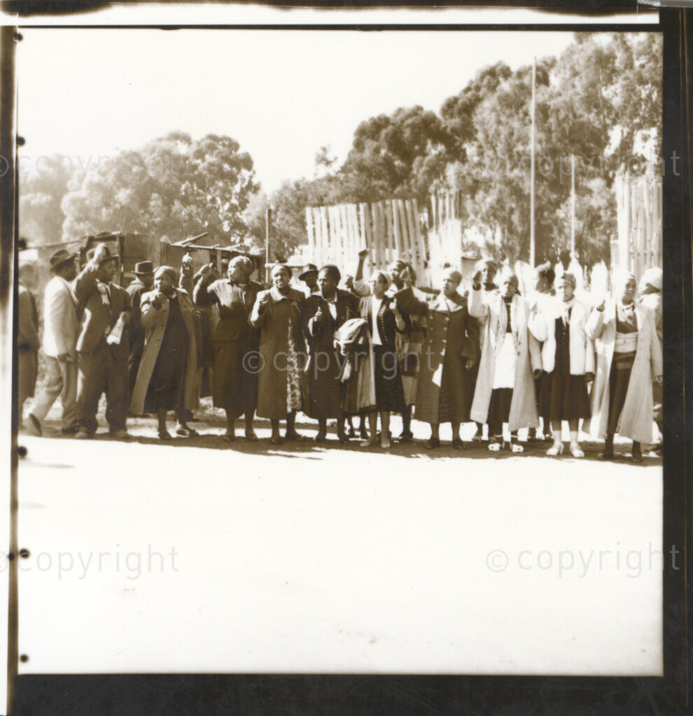 Kliptown, Johannesburg, Transvaal (now Gauteng), South Africa, 19550625. PHOTO: Eli Weinberg.
A group of men and women make the thumbs up salute. They may be delegates attending the Congress of the People held in Kliptown, Johannesburg on June 25 and 26th 1955. The Freedom Charter was adopted at this Congress. The Freedom Charter was the statement of the core principles of the South African Congress Alliance and was developed after wide consultation with people from all over South Africa. The Congress Alliance consisted of the African National Congress (ANC) and its allies the South African Indian Congress (SAIC), the South African Congress of Democrats (SACOD) and the Coloured People`s Congress (CPC).