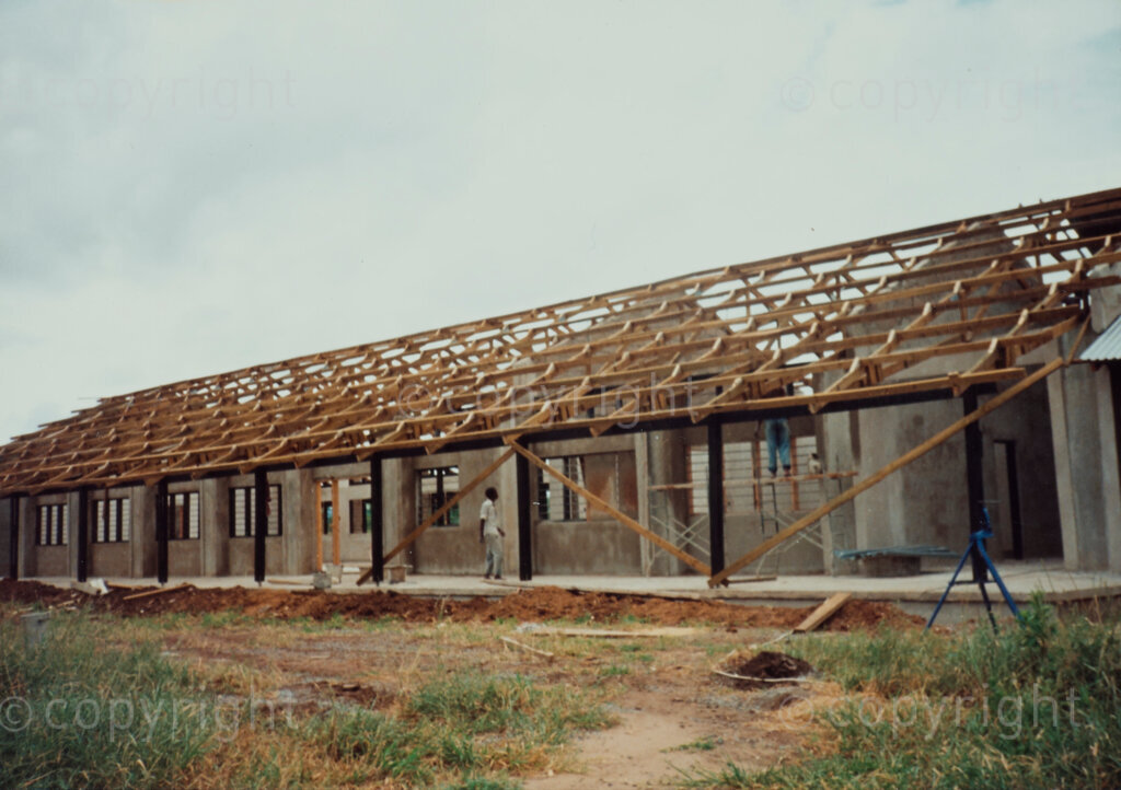 Dakawa, Morogoro, Morogoro Region, Tanzania, 1980s. PHOTO: ANC Archives.
Construction of the ANC Development Centre at Dakawa.
Following the SOWETO Uprising in South Africa in 1976 in which thousands of young people arrived in exile unaccompanied by parents or adults, the ANC establishes two major projects in Tanzania, SOMAFCO at Mazimbu and the ANC Development Centre at Dakawa. SOMAFCO is built on a 250 Ha former sisal farm called Mazimbu in Morogoro, which the Tanzanian Government gave to the ANC. In 1980 the Tanzanian Government gives another farm near Morogoro called Dakawa. The 300 Ha property is used to establish the ANC Development Centre.
The main goal of the ANC Development Centre is to establish a reception and orientation centre in Tanzania to provide asylum-seeking young South Africans with housing, remedial education, and vocational skills to regain self-respect, independence, and ultimately contribute to their country's development. Unlike SOMAFCO, which is conceived as a school, the ANC Development Centre is to serve as a community settlement, with plans for eight self-sufficient villages focusing primarily on agriculture and small-scale industry.
The Development Centre encompasses various activities and facilities, including agriculture, construction projects, educational centres such as the Ruth First Educational Orientation Centre and the Institute of South African Studies, vocational training, adult education, and plans for a political education school.