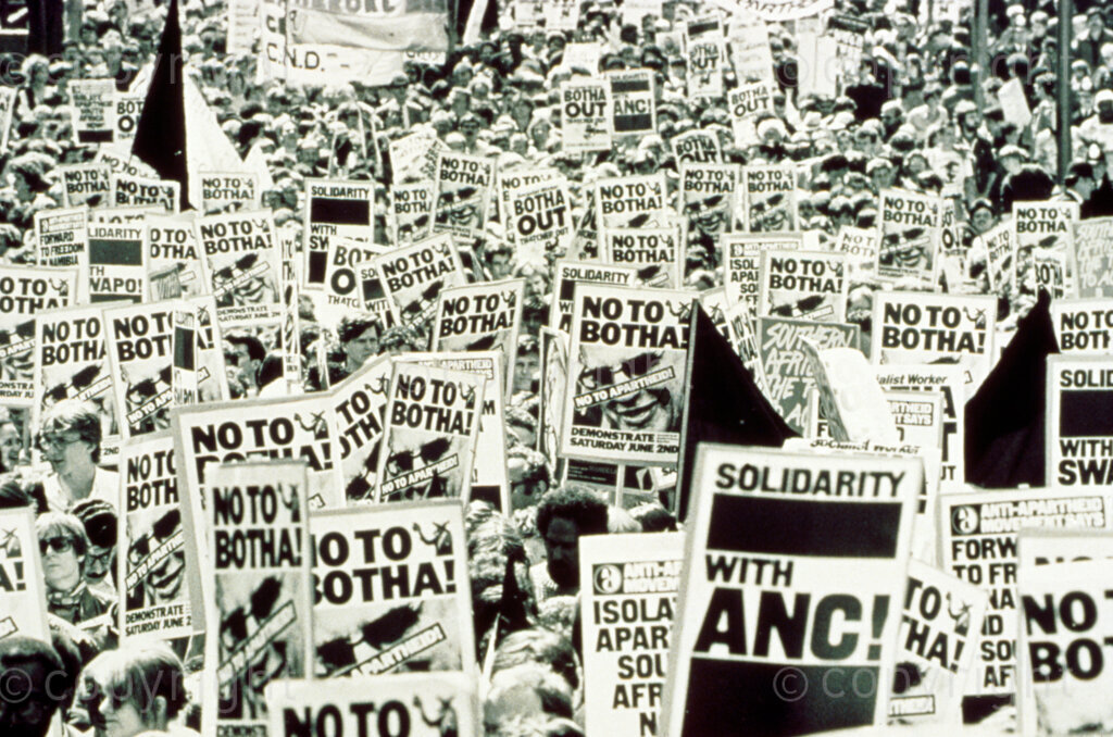 Location and Date Unknown. PHOTO: ANC Archives.
'No to Botha and Solidarity with ANC!' written on posters carried by marchers at an anti-apartheid march. This may have been at the time of the referendum called by President Botha for White voters to decide on the parliament, on 2 November 1983. The resistance movements within the country and outside the country called for a 'No' vote by White voters since Black South Africans were left out of the deal and only Indian and Coloured South Africans were included in Botha's deal. There are some banners in this protest from the Committee on Nuclear Disarmament (CND).