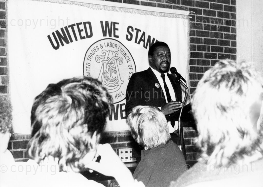 South Australia, Australia, Date Unknown PHOTO: ANC Archives.

Eddie Funde addressing a meeting of the United Trades and Labor Council of South Australia , the peak body for trade unions in South Australia. The banner behind him has the logo and 