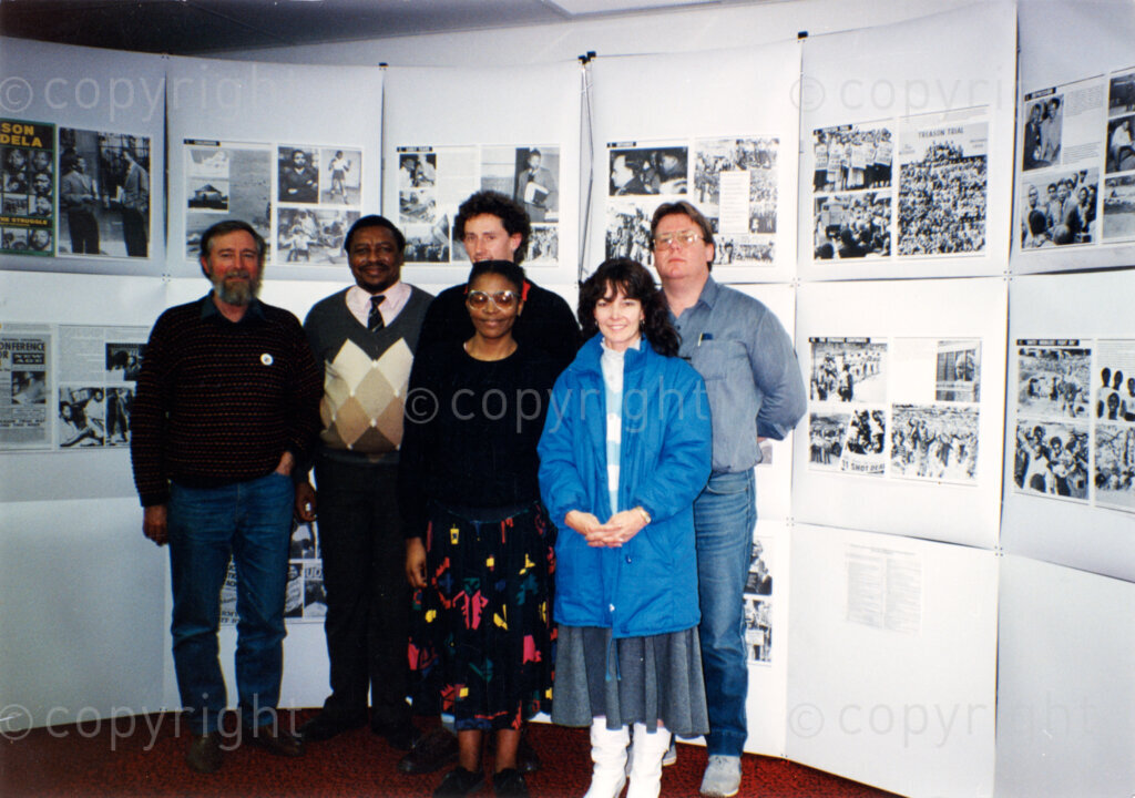 Iron Workers Club, Wollongong, New South Wales, Australia, 19890824. PHOTO: ANC Archives.

Six members pose in front of an exhibition of ANC photos at the formation of the Wollongong African National Congress (ANC) Group, at the Iron Workers Club in Wollongong, New South Wales, Australia on 24 August 1989. From left to right back row: Terry Fox, Eddie Funde, Steven Jones, Mick Owens. Front row left to right: Busi and Heather Stanton. Eddie Funde was Chief Representative of the ANC's Australasia and Pacific Mission (1983 - 1991). Photo taken by Doreen Borrow.