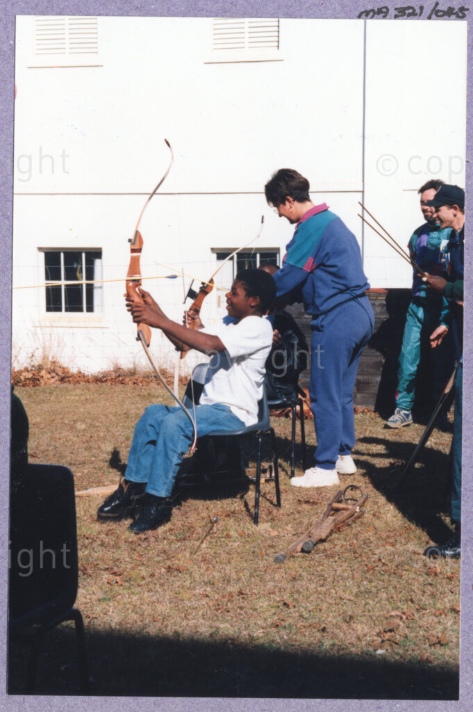 Hilton College, Pietermaritzburg, KwaZulu-Natal, South Africa, 19960717. PHOTO: ANC Archives.

A young boy living with disability is taught to shoot with a bow at the 78th birthday celebration of the President of South Africa, Nelson Mandela. More than 2,000 children who are living with disability in disadvantaged communities across the county have been invited to attend the day-long birthday extravaganza being held on the 17th July 1996 on the grounds of Hilton College near Pietermaritzburg in the KwaZulu-Natal Midlands. In advance of today's festivities, the invited children have been examined and treated by a team of orthopaedic specialists and physiotherapists. Many of them have been given life-changing wheelchairs. The event has the backing of the Nelson Mandela Children's Fund. Nelson Mandela was born on the 18th July 1918 in Mvezo, a small village in the Eastern Cape.
