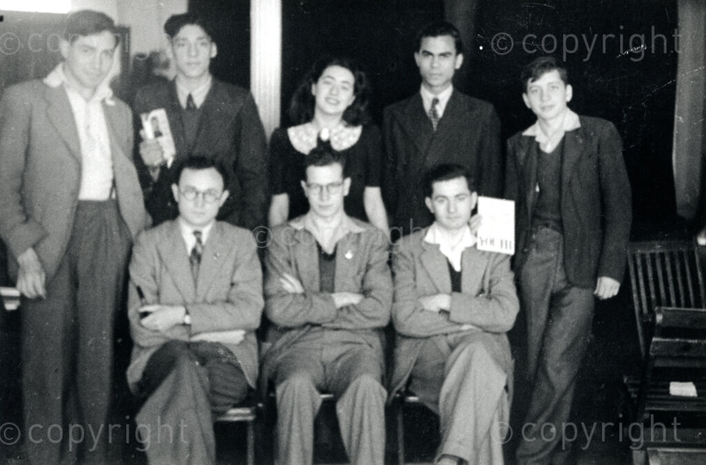 Location and Date Unknown.  PHOTO: ANC Archives.

Back row from left to right: Basil Jaffe, Ronnie Forgus, Myra Baskin, J. Ross, Lionel Forman.
Seated from left to right: B. Uranousky, J. Schadrin, T. Myers.  Lionel Forman was a member of SACP. He was a lawyer and a journalist. He was one of the treason trialists in the 1956 Treason Trial and died in October 1959 during a heart operation at the age of 31.