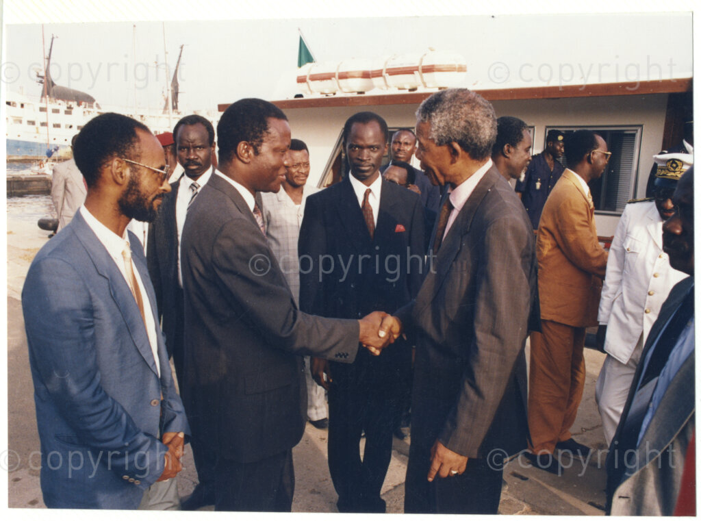 Senegal, 19920601. PHOTO: ANC Archives.

Nelson Mandela (first from right) is seen standing next to a boat and greeting an unidentified man (second from left) on his official visit to Senegal in June 1992.