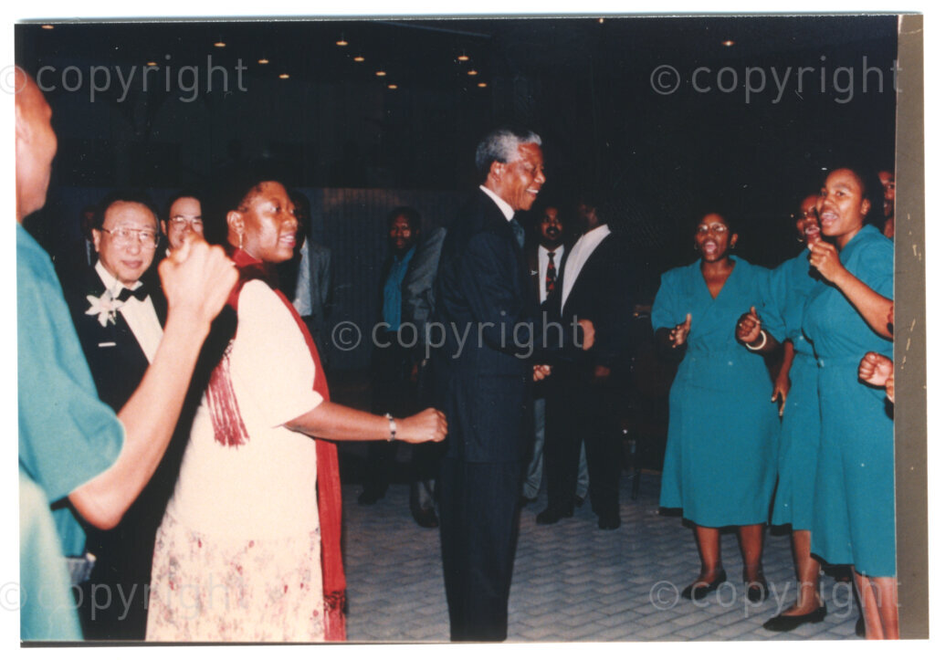 Parktonian Hotel, Johannesburg, Transvaal, South Africa, 19940309. PHOTO: ANC Archives.

The President of the African National Congress (ANC), Nelson Mandela (centre), enjoys dancing with women dressed in uniforms suggesting they are hotel staff at an ANC voter education fund-raising dinner hosted by the Taiwanese community in South Africa on the 9 March 1994. Leading up to the 1994 elections in South Africa, Taiwan embarked on a public relations campaign in efforts to improve relations with the ANC, providing financial support to the ANC's election campaign. South Africa's diplomatic ties with Taiwan (The Republic of China) ended in 1998 however when Nelson Mandela, as President of South Africa, recognized the People's Republic of China.