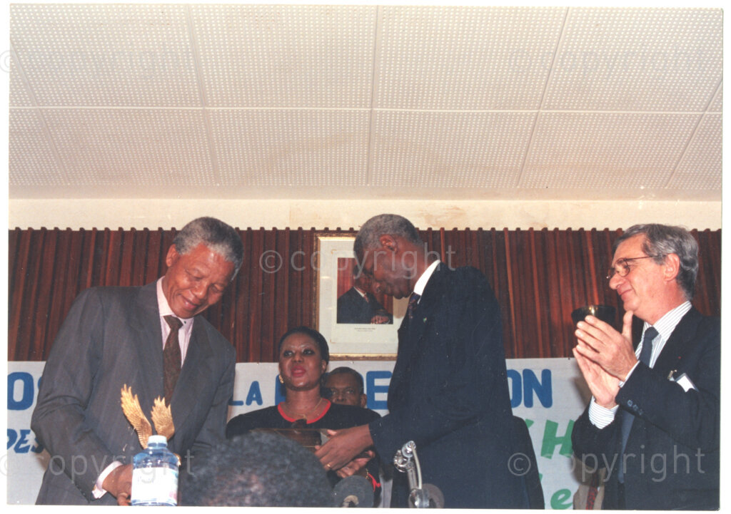 Senegal, 19920601. PHOTO: ANC Archives.

Nelson Mandela (left) is presented with an award by Senegalese President Abdou Diouf (centre), during Mandela's visit to Senegal in June 1992, possibly at the Twenty-Eighth Assembly of Heads of States and Government of the Organisation of African Unity (OAU) in Dakar.