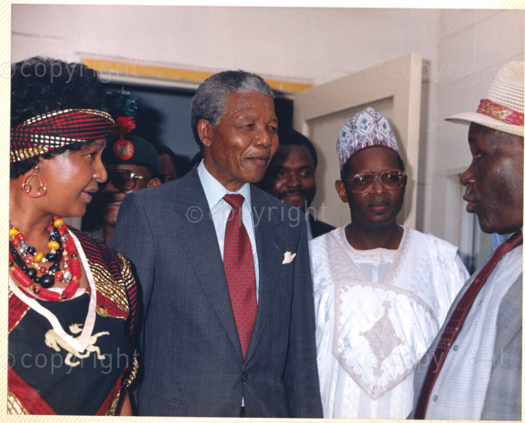 Kaduna Refinery, Kaduna, Kaduna, Nigeria, 19900515. PHOTO: ANC Archives.

Winnie Madikizela-Mandela (left) and Nelson Mandela (center) listen to an unidentified individual during their visit to Kaduna Refinery, Nigeria, 15 May 1990.