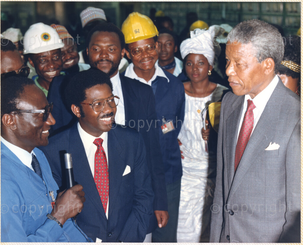 Kaduna Refinery, Kaduna, Kaduna, Nigeria, 19900515. PHOTO: ANC Archives.

Nelson Mandela (right) listens to an unidentified official during his tour of Kaduna Refinery, Nigeria, 15 May 1990.