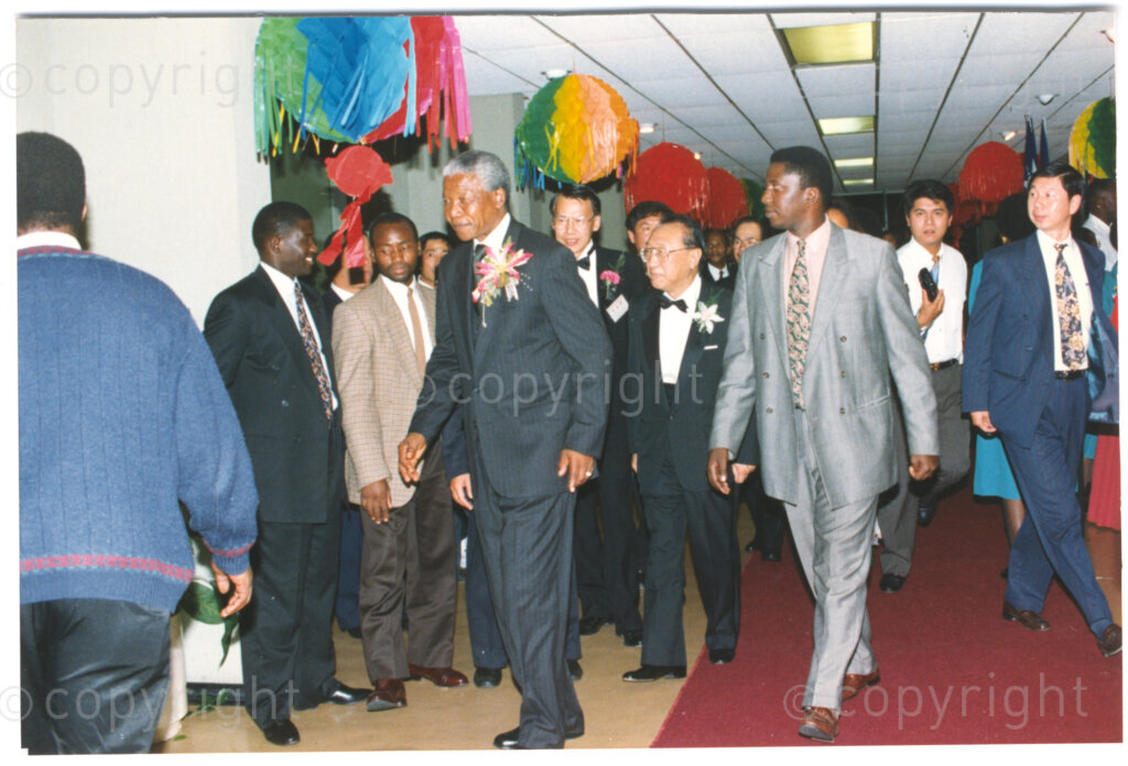 Parktonian Hotel, Johannesburg, Transvaal, South Africa, 19940309. PHOTO: ANC Archives.

The President of the African National Congress (ANC), Nelson Mandela, walks down the red carpet with other official guests at an ANC voter education fund-raising dinner hosted by the Taiwanese community in South Africa on the 9 March 1994. Leading up to the 1994 elections in South Africa, Taiwan embarked on a public relations campaign in efforts to improve relations with the ANC, providing financial support to the ANC's election campaign. South Africa's diplomatic ties with Taiwan (The Republic of China) ended in 1998 however when Nelson Mandela, as President of South Africa, recognized the People's Republic of China.