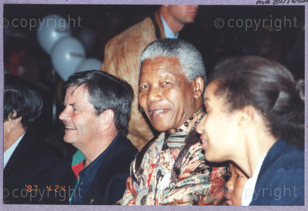 Hilton College, Pietermaritzburg, KwaZulu-Natal, South Africa, 19960717. PHOTO: ANC Archives.

Seated among his guests and next to his small grandson, the President of South Africa, Nelson Mandela, enjoys a circus performance in the big top tent erected for his 78th birthday celebration on the 17th July 1996 on the grounds of Hilton College near Pietermaritzburg in the KwaZulu-Natal Midlands. More than 2,000 children who are living with disability in disadvantaged communities have come from across the country to celebrate Madiba's birthday with him. The circus experience is a first for most of the children, as well as for the country's president! Later in the day, Nelson Mandela took the opportunity to speak to sponsors and business people gathered for the event about the importance of civil society working together to ensure that the needs of disabled children are incorporated into every programme for children. The event has the backing of the Nelson Mandela Children's Fund.