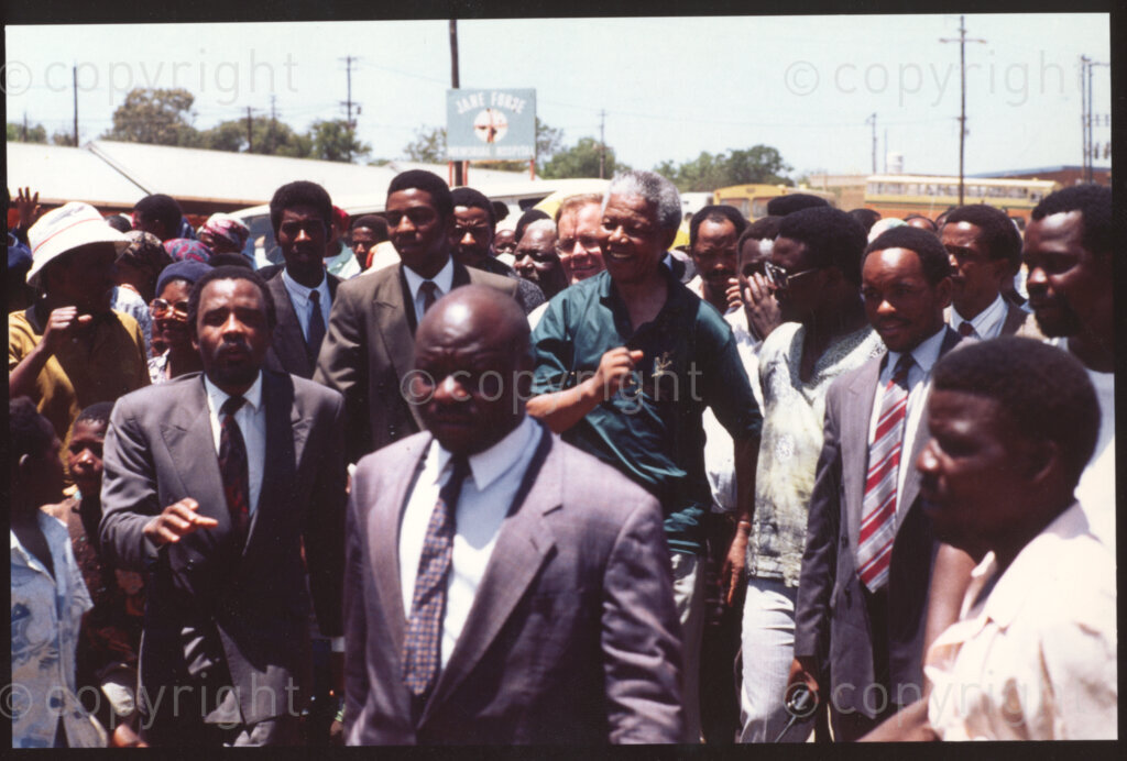 Jane Furse Hospital , Jane Furse , Sekhukhuneland, Transvaal, South Africa, 19921130. PHOTO: ANC Archives.

Crowds escort the President of the African National Congress (ANC), Nelson Mandela (centre), through the grounds of the Jane Furse Hospital on a visit to the town in November 1992.