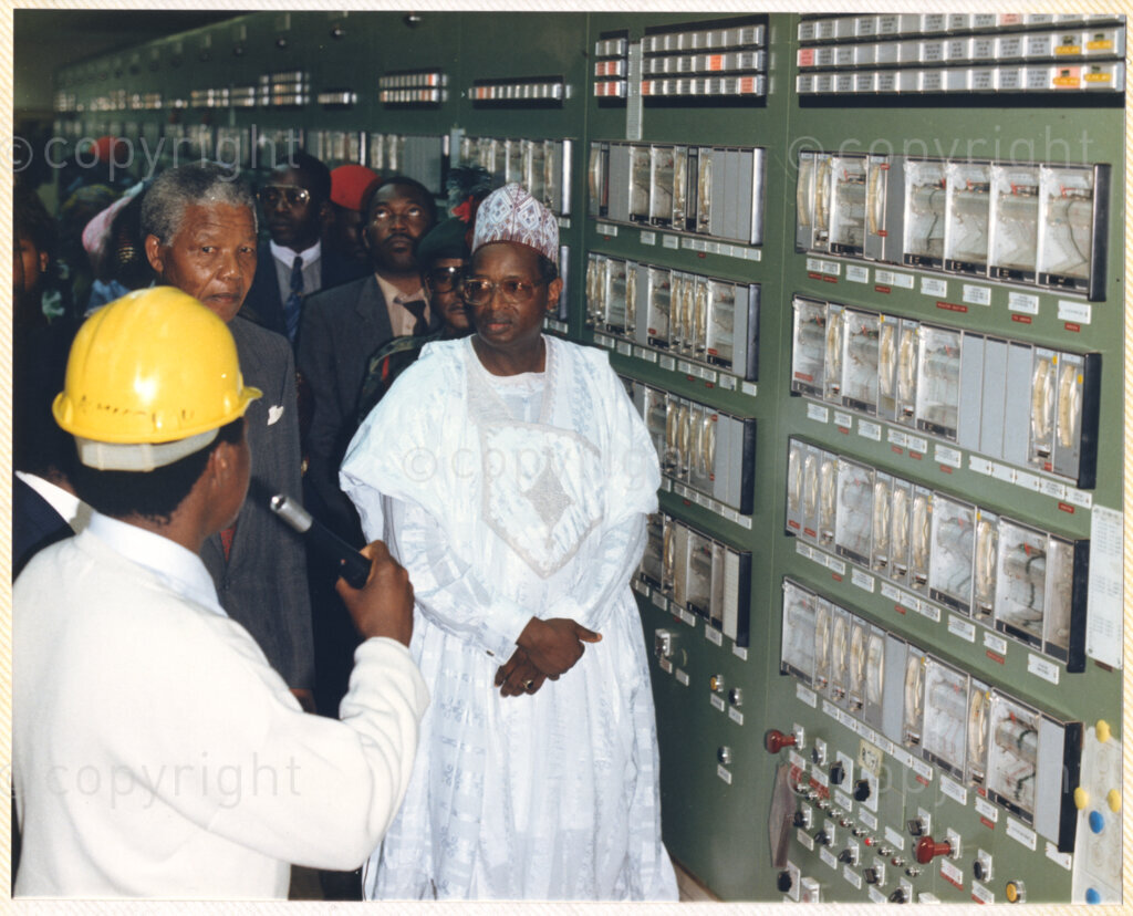 Kaduna Refinery, Kaduna, Kaduna, Nigeria, 19900515. PHOTO: ANC Archives.

Nelson Mandela (center) listens to an unidentified official during his tour of Kaduna Refinery, Nigeria, 15 May 1990.