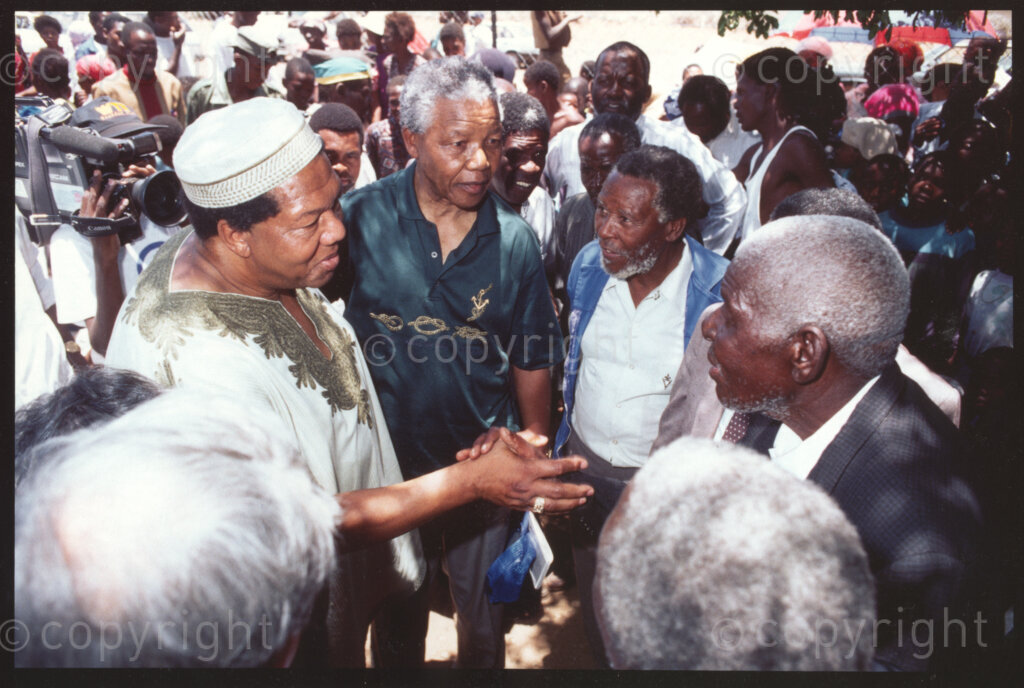 Maila Mapitsane village , Sekhukhuneland, Transvaal, South Africa, 19921130. PHOTO: ANC Archives.

The President of the African National Congress, Nelson Mandela (centre) introduces the Chief of the Maila Mapitsane village (right) to the Chairman of Operation Hunger, Michael Rantho (extreme left in a white tunic) at a gathering in the village in November 1992.