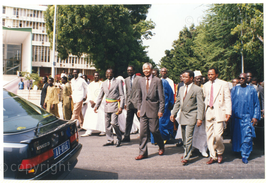 Senegal, 19920601. PHOTO: ANC Archives.

Nelson Mandela (Centre), walking with unidentified men (some with traditional clothes) during his visit to Senegal in June 1992.