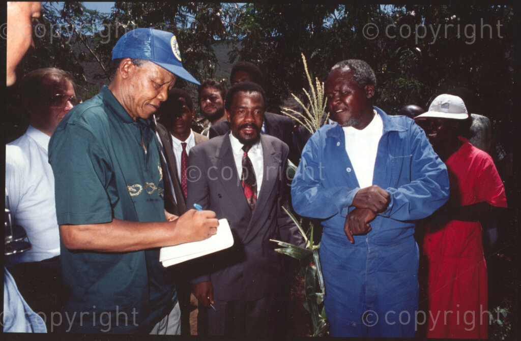 Seopela village, Sekhukhuneland, Transvaal, South Africa, 19921130. PHOTO: ANC Archives.

The President of the African National Congress (ANC), Nelson Mandela, makes notes as he talks to a plot owner at the Mohlala Garden in the village of Seopela in the Sekhukhuneland region in November 1992.