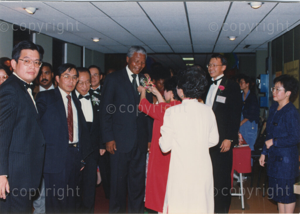 Parktonian Hotel, Johannesburg, Transvaal, South Africa, 19940309. PHOTO: ANC Archives.

The President of the African National Congress (ANC), Nelson Mandela, receives an elaborate tiger lily corsage upon arrival at an ANC voter education fund-raising dinner hosted by the Taiwanese community in South Africa on the 9 March 1994. Leading up to the 1994 elections in South Africa, Taiwan embarked on a public relations campaign in efforts to improve relations with the ANC, providing financial support to the ANC's election campaign. South Africa's diplomatic ties with Taiwan (The Republic of China) ended in 1998 however when Nelson Mandela, as President of South Africa, recognized the People's Republic of China.