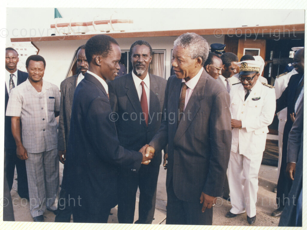 Senegal, 19920601. PHOTO: ANC Archives.

 A photo of many people with Nelson Mandela (right) greeting an unidentified man (left), during Mandela's visit to Senegal in June 1992.