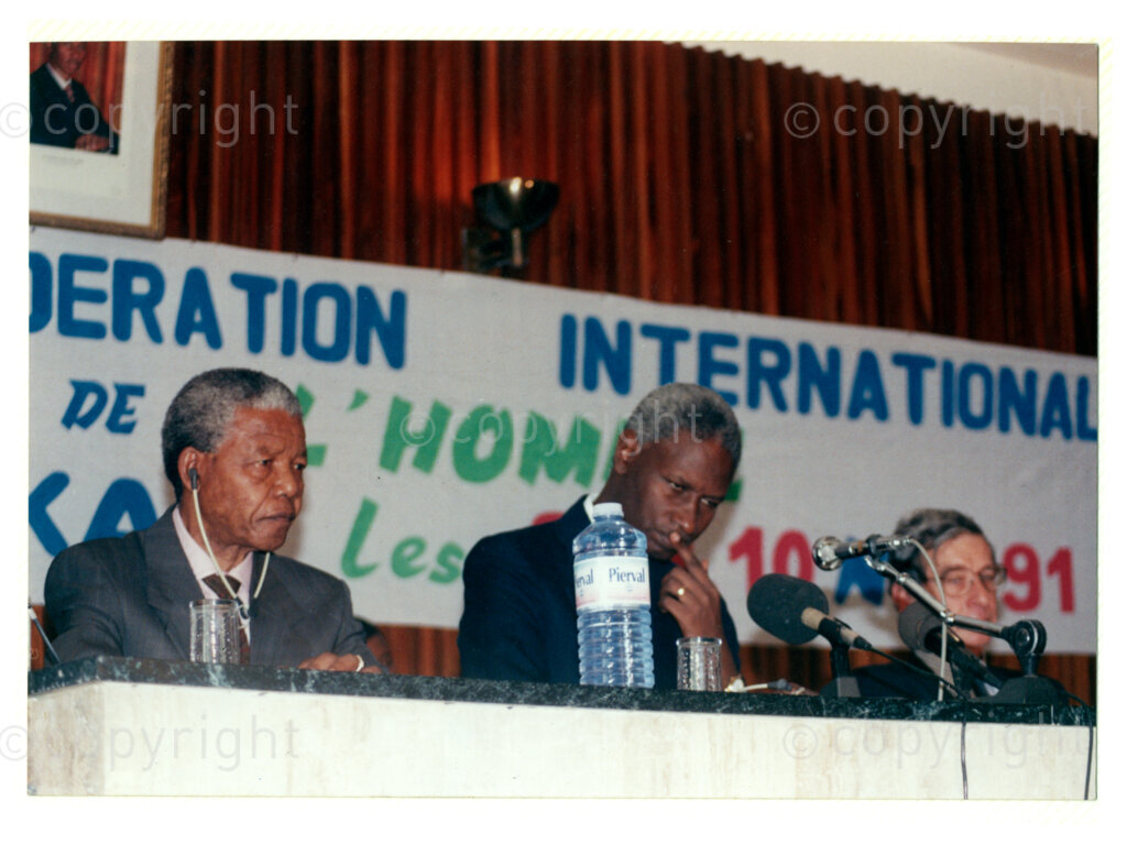 Senegal, 19920601. PHOTO: ANC Archives.

Nelson Mandela (left) is seated next to Senegalese President, Abdou Diouf (centre) and an unidentified man (right), during Mandela's visit to Senegal in June 1992, possibly during the Twenty-Eighth Assembly of Heads of States and Government of the Organisation of African Unity (OAU) in Dakar.