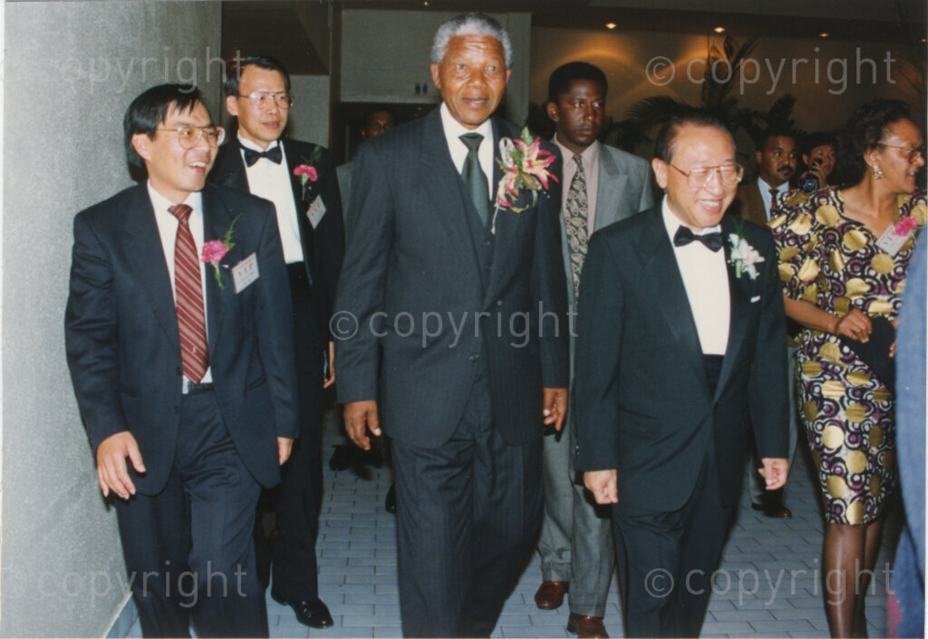 Parktonian Hotel, Johannesburg, Transvaal, South Africa, 19940309. PHOTO: ANC Archives.

The President of the African National Congress (ANC), Nelson Mandela (second left), is escorted by officials into the function venue at an ANC voter education fund-raising dinner hosted by the Taiwanese community in South Africa on the 9 March 1994. Leading up to the 1994 elections in South Africa, Taiwan embarked on a public relations campaign in efforts to improve relations with the ANC, providing financial support to the ANC's election campaign. South Africa's diplomatic ties with Taiwan (The Republic of China) ended in 1998 however when Nelson Mandela, as President of South Africa, recognized the People's Republic of China.