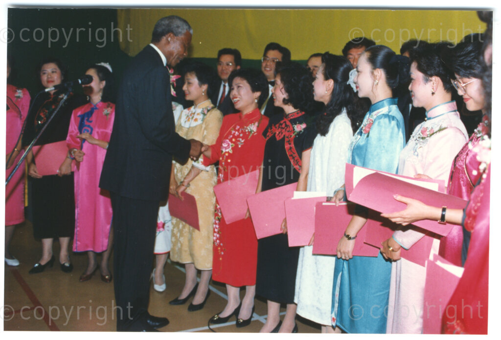 Parktonian Hotel, Johannesburg, Transvaal, South Africa, 19940309. PHOTO: ANC Archives.

The President of the African National Congress (ANC), Nelson Mandela, moves along a line of young women dressed in traditional Taiwanese dress at an ANC voter education fund-raising dinner hosted by the Taiwanese community in South Africa on the 9 March 1994. Leading up to the 1994 elections in South Africa, Taiwan embarked on a public relations campaign in efforts to improve relations with the ANC, providing financial support to the ANC's election campaign. South Africa's diplomatic ties with Taiwan (The Republic of China) ended in 1998 however when Nelson Mandela, as President of South Africa, recognized the People's Republic of China.