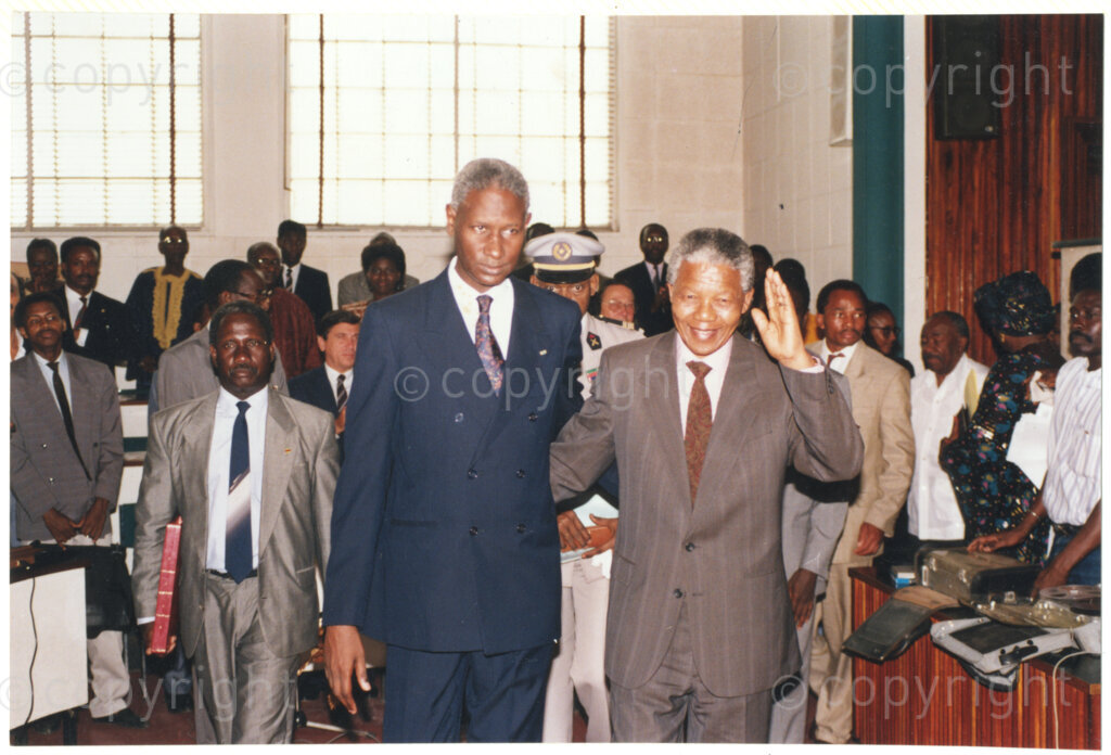 Senegal, 19920601. PHOTO: ANC Archives.

Nelson Mandela (right, waving) is seen walking next to Senegalese President, Abdou Diouf (Left), during Mandela’s visit to Senegal in June 1992.