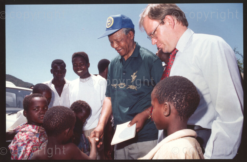 Jane Furse Agricultural Centre, Jane Furse, Sekhukhuneland, Transvaal, South Africa, 19921130. PHOTO: ANC Archives.

Carl Niehaus of the ANC (right in the white shirt), and the President of the ANC, Nelson Mandela (centre) greet children at Operation Hunger's Jane Furse Agricultural Centre in the town of Jane Furse, Sekhukhuneland in November 1992.