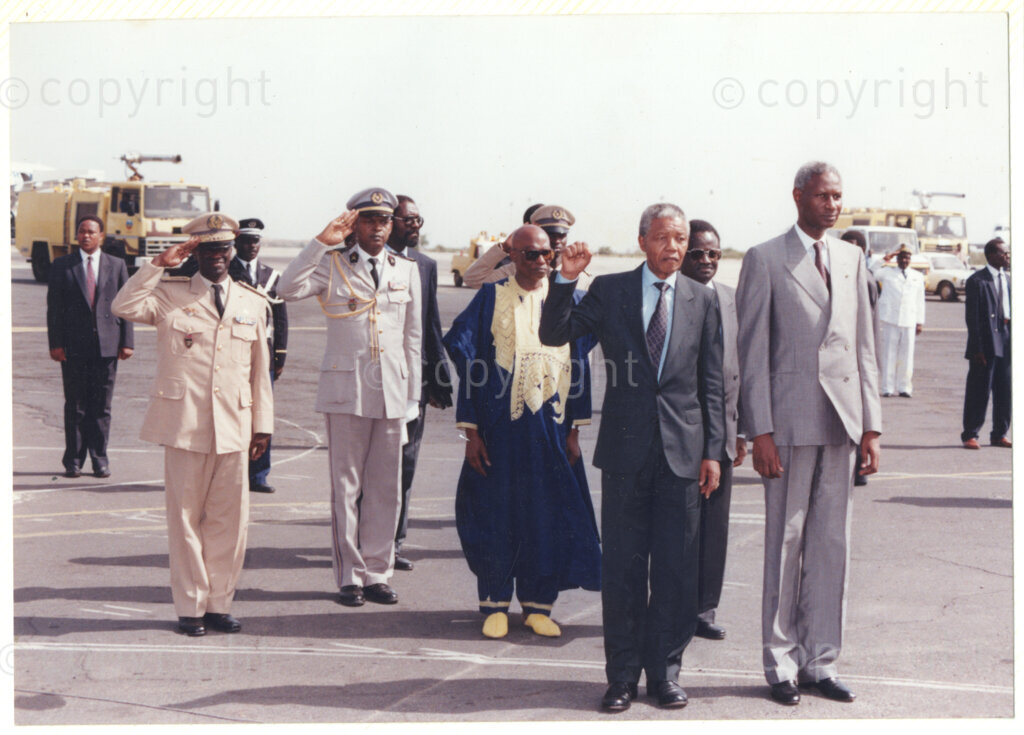 Senegal, 19920601. PHOTO: ANC Archives.

Nelson Mandela (left with his fist raised) is standing next to the Senegalese President, Abdou Diouf (right) during an official welcome ceremony on Mandela's arrival in Senegal in June 1992.