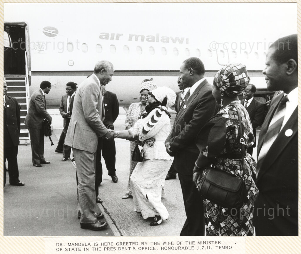 Chileka Airport, Blantyre, , Malawi, 19920617. PHOTO: ANC Archives.

Nelson Mandela is welcomed by the wife of the then Minister of State in the President's Office, Honourable J.Z.U Tembo upon his arrival at Chileka Airport, Malawi on 17 June 1992.
