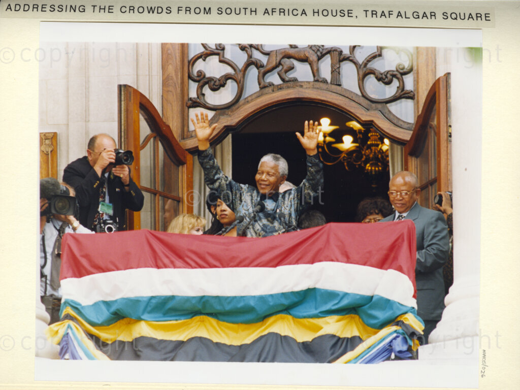 South Africa House, Trafalgar Square, London, United Kingdom, 19960701. PHOTO: ANC Archives: 
In July 1996, President Nelson Mandela is on a state visit to the United Kingdom. He addresses a large crowd from the balcony of South Africa House, on Trafalgar Square. He receives a tumultuous acknowledgement.