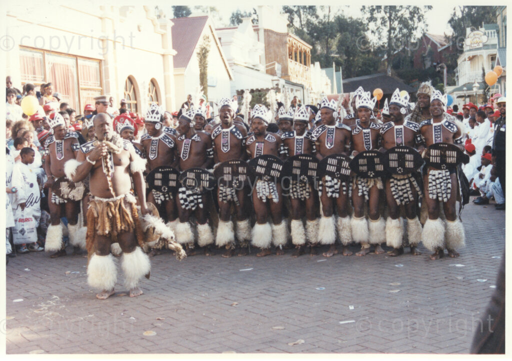 Gold Reef City, Johannesburg, Gauteng, South Africa, 19950717. PHOTO: ANC Archives.

Zulu dancers dressed in traditional attire entertain the guests as they await the arrival of the President of South Africa, Nelson Mandela, at his 77th birthday celebration at Gold Reef City, Johannesburg, on Monday the 17th July 1995. More than 2,000 underprivileged children, including 34 children who are currently imprisoned, street children, children from orphanages, mentally disabled children and children who have been abused, have been invited to attend his birthday celebration with him. Nelson Mandela is attending this function in his personal capacity as he places special emphasis on the plight of children. Other entertainments that have been put on for the children include performances by Zip Zap social circus and Azumah, the traditional music and dance performing group.