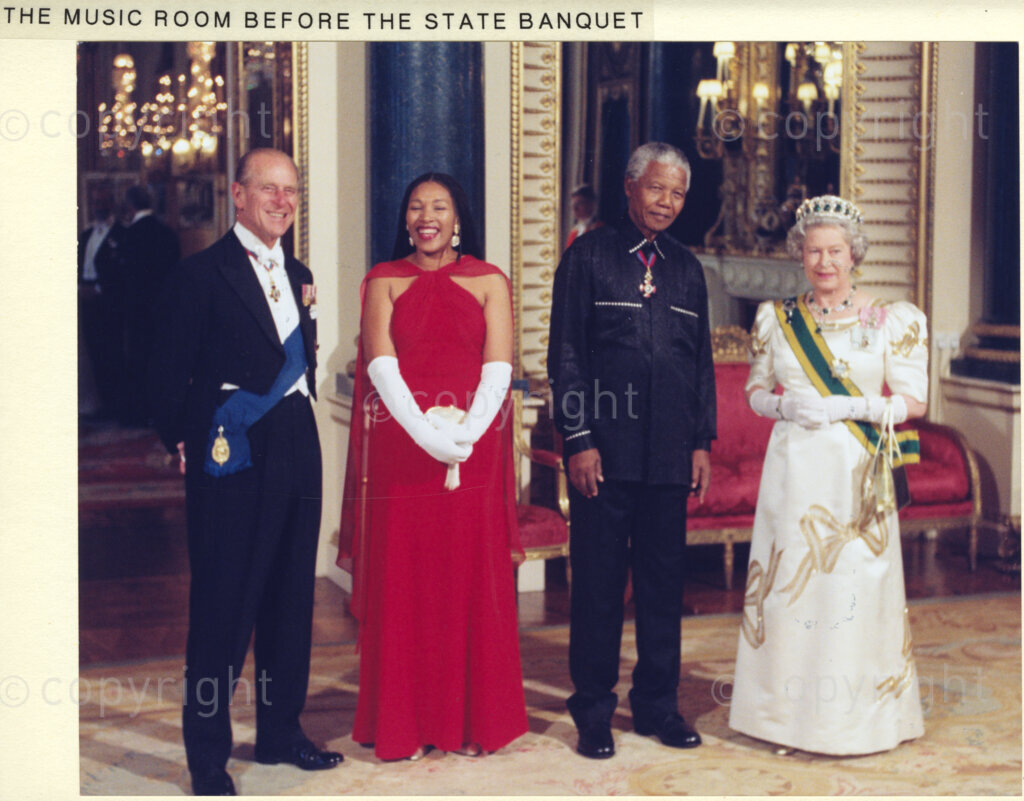 Buckingham Palace, Music Room, London, United Kingdom, 19960701. PHOTO: ANC Archives: 1996 State visit to the United Kingdom by President Nelson Mandela. The royal couple, Prince Phillip, (left), and Queen Elizabeth II, (right), pose with President Nelson Mandela and his daughter, Zindzi, (wearing red), in the Music Room at Buckingham Palace. They are about to dine at the state banquet which is held in Mandela's honour.