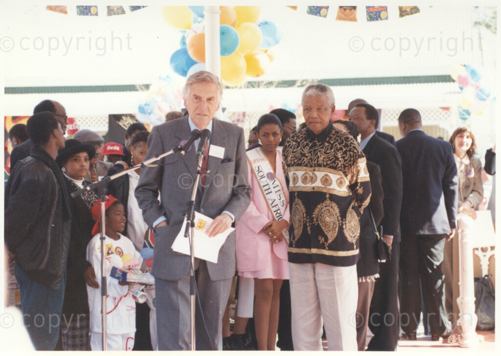 Gold Reef City, Johannesburg, Gauteng, South Africa, 19950717. PHOTO: ANC Archives.

The President of South Africa, Nelson Mandela, is invited to take the microphone at the ceremony at which he is to receive donations towards the Nelson Mandela Children's Fund from the private sector to mark the occasion of his 77th birthday celebration at Gold Reef City, Johannesburg, on Monday the 17th July 1995. Miss South Africa (1994), Ms Basetsana Makgalemele (centre) looks on. More than 2,000 underprivileged children, including 34 children who are currently imprisoned, street children, children from orphanages, mentally disabled children and children who have been abused, have been invited to attend his birthday celebration with him. Madiba is attending this function in his personal capacity as he places special emphasis on the plight of children.