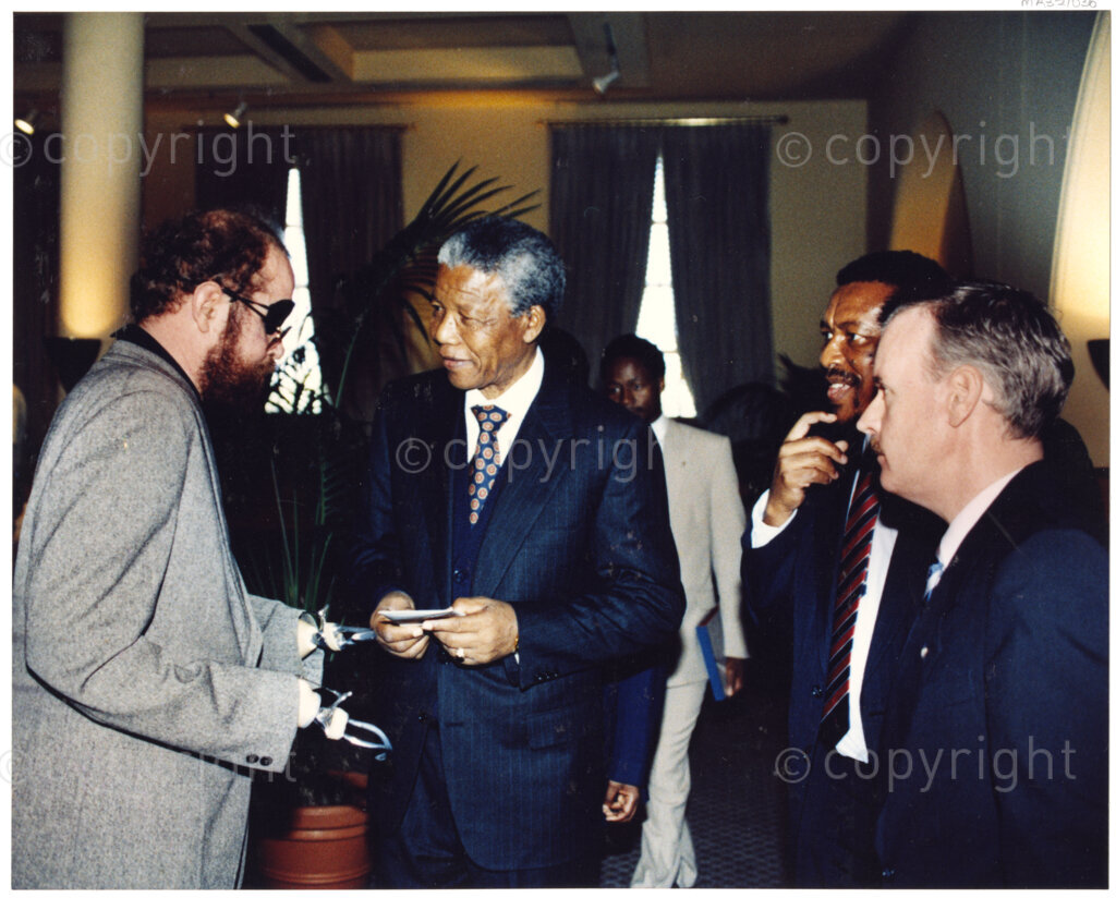 Australia, October 1990. PHOTO: ANC Archives: On his first trip to Australia in 1990, Nelson Mandela, (second from the left), Deputy President of the African National Congress, seizes every opportunity to interact with policy-makers, politicians, business leaders, diplomats and ordinary people. He believes he owes the Australians a debt of gratitude for the pressure they brought to bear on the South African apartheid regime in the past decades. Despite this, Australia has yet to address its own discriminatory policies. (Mandela converses here with unnamed dignitaries.) Monday 22 October to Saturday 27 October 1990.
