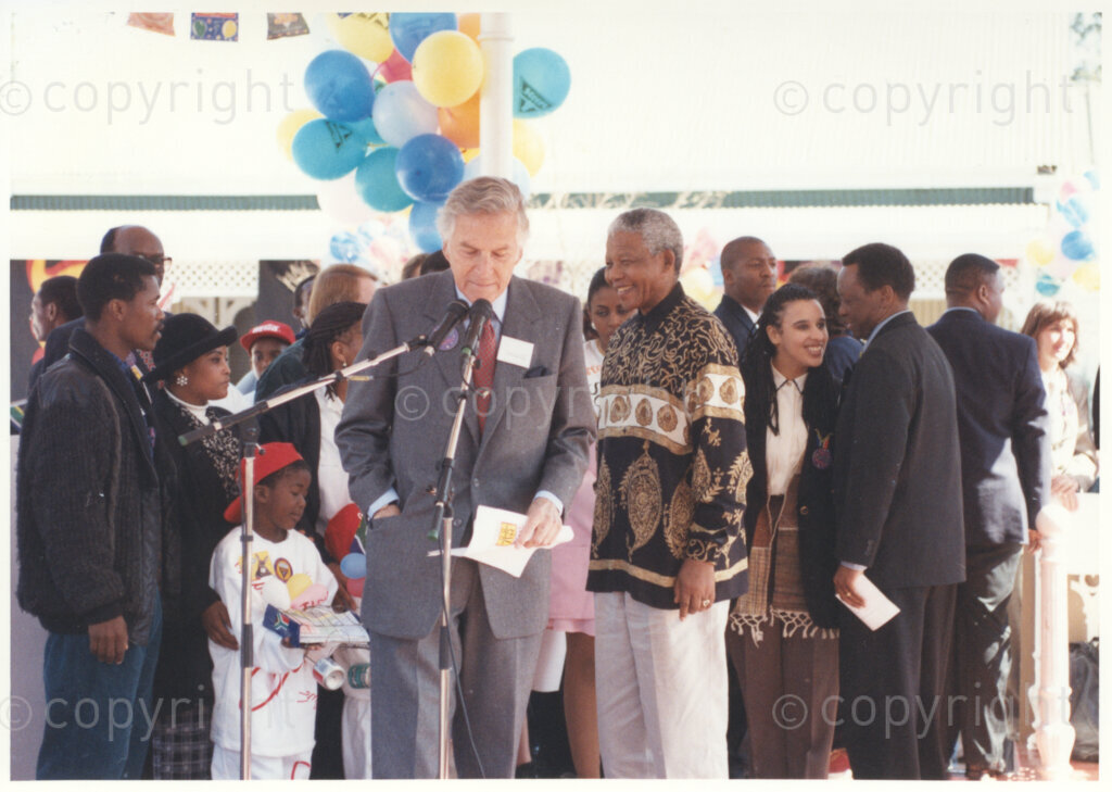 Gold Reef City, Johannesburg, Gauteng, South Africa, 19950717. PHOTO: ANC Archives.

An official makes a speech at a small ceremony at which the President of South Africa, Nelson Mandela (right), receives a number of donations towards the Nelson Mandela Children's Fund to mark the occasion of his 77th birthday celebration at Gold Reef City, Johannesburg, on Monday the 17th July 1995. Immediately behind Nelson Mandela, stand Miss South Africa (1994) Miss Basetsana Makgalemele (in pink) and Nelson Madiba's grandniece Rochelle Mtirara. More than 2,000 underprivileged children, including 34 children who are currently imprisoned, street children, children from orphanages, mentally disabled children and children who have been abused, have been invited to attend his birthday celebration with him. Nelson Mandela is attending this function in his personal capacity as he places special emphasis on the plight of children.