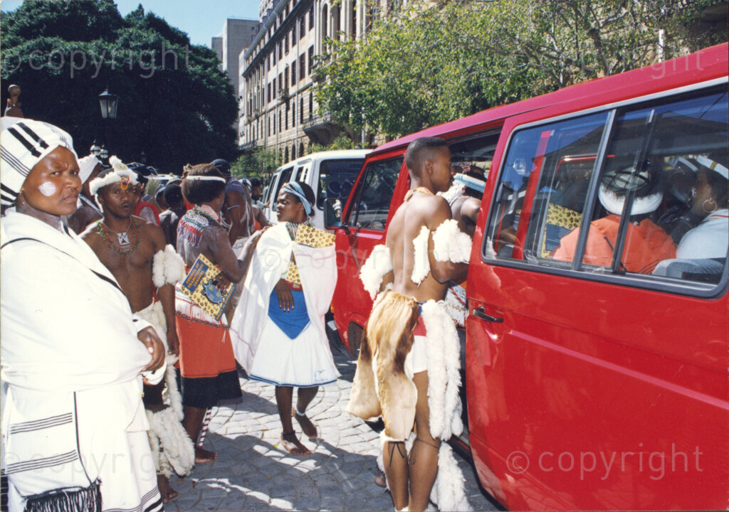 Cape Town, Western Cape, South Africa, 19970418. PHOTO: ANC Archives.

A group of males and females in traditional Zulu and Xhosa dress stand beside a red minibus taxi at the inauguration of the National Council of Traditional Leaders in Cape Town, Western Cape, South Africa on 18 April 1997.