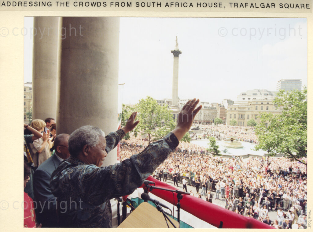 South African House, Trafalgar Square, London, United Kingdom, 19960701. PHOTO: ANC Archives: On his state visit to the United Kingdom in July 1996, President Nelson Mandela addresses jubilant crowds from the balcony of South Africa House in Trafalgar Square, London.