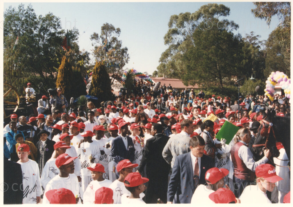 Gold Reef City, Johannesburg, Gauteng, South Africa, 19950717. PHOTO: ANC Archives.

A large group of underprivileged children dressed in new white tracksuits and red caps enjoy the festivities at the 77th birthday celebration of the President of South Africa, Nelson Mandela, at Gold Reef City, Johannesburg, on Monday the 17th July 1995. More than 2,000 children, including 34 children who are currently imprisoned, street children, children from orphanages, mentally disabled children and children who have been abused, have been invited to attend his birthday celebration with him. Nelson Mandela is attending this function in his personal capacity as he places special emphasis on the plight of children. A variety of entertainments have been put on for the children, including performances by Zip Zap social circus and Azumah, the traditional music and dance performing group.