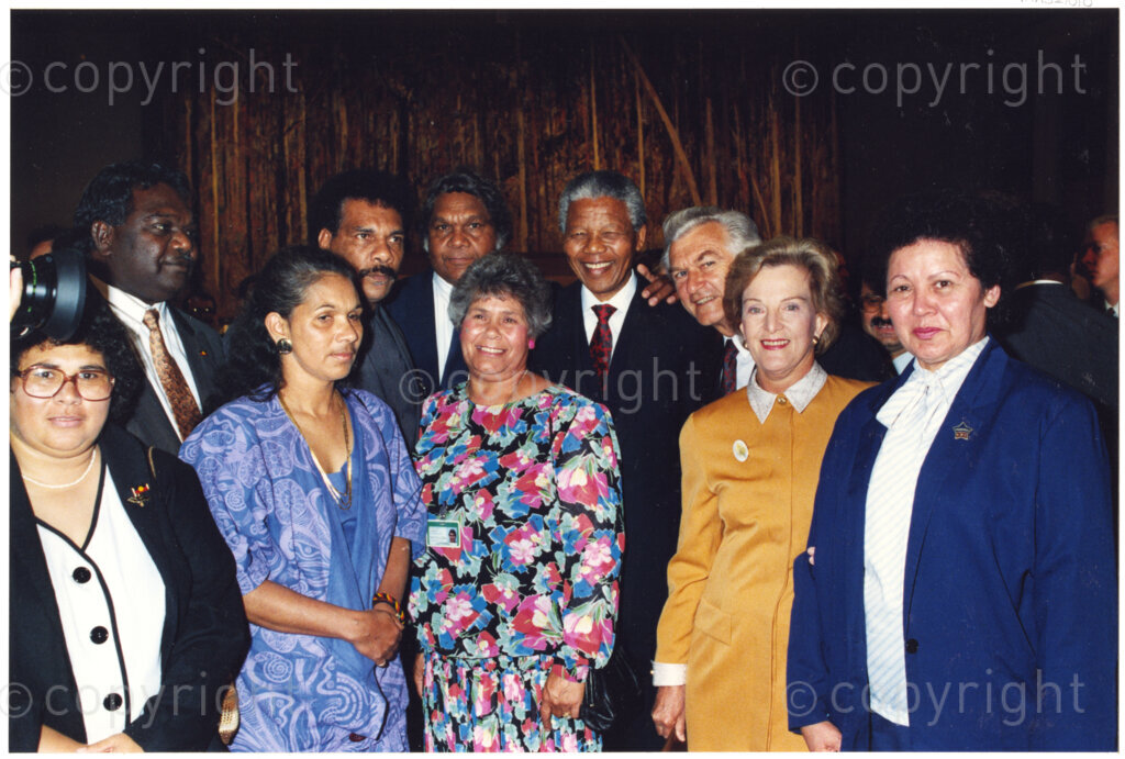 Australia, October 1990. PHOTO: ANC Archives: Prime Minister Bob Hawke stands to the left of Nelson Mandela, Deputy President of the African National Congress. The wife of the Prime Minister wears a gold dress. The group surrounding Mandela comprise citizens and dignitaries from all walks of Australian life. Monday 22 October to Saturday 27 October 1990.