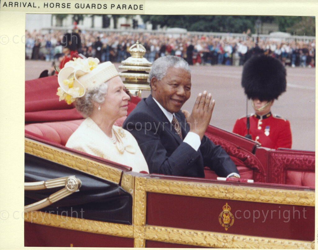 The Mall, London, United Kingdom, 19960701. PHOTO: ANC Archives: President Nelson Mandela pays a state visit to the United Kingdom in July 1996. Mandela is seen here with Queen Elizabeth II. They drive down The Mall in a state landau. Crowds of people give Mandela a tumultuous welcome.